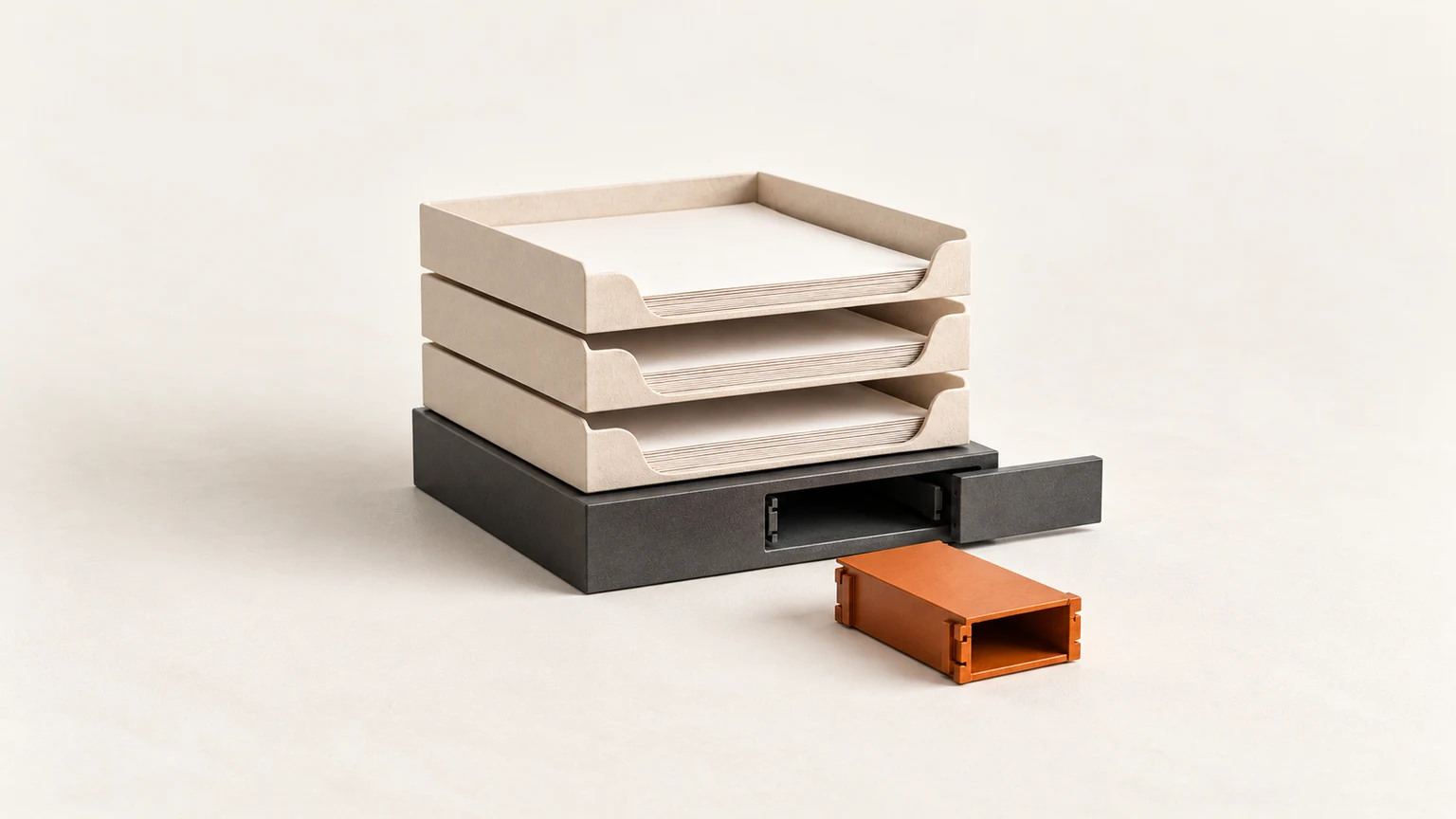 Three cream paper trays on a graphite base with its front panel half open, exposing an empty slot beside an orange replacement module.